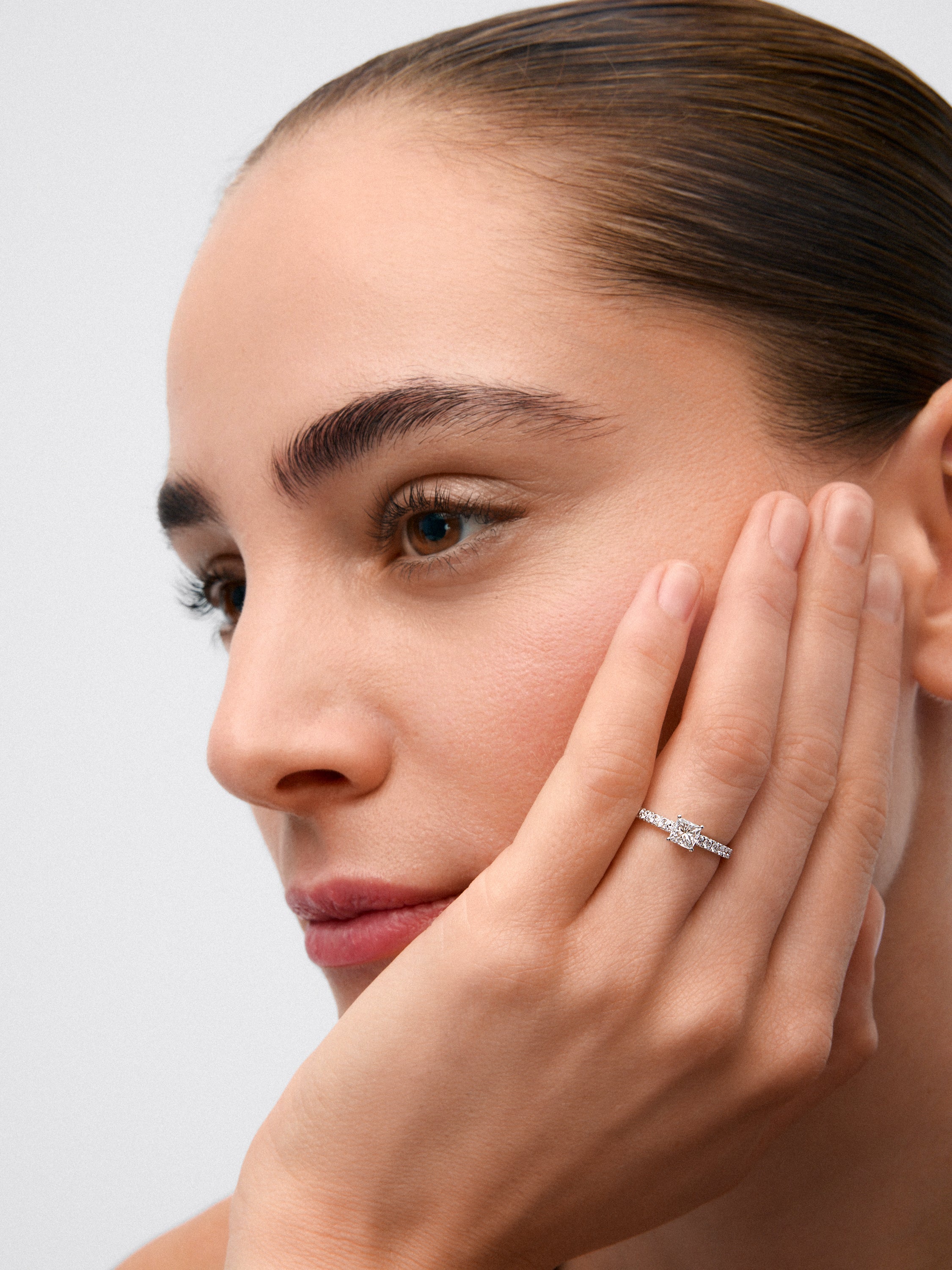 Anillo de oro blanco de 18K con diamante central en talla princesa de 0,5 cts y 14 diamantes con un total de 0,25 cts