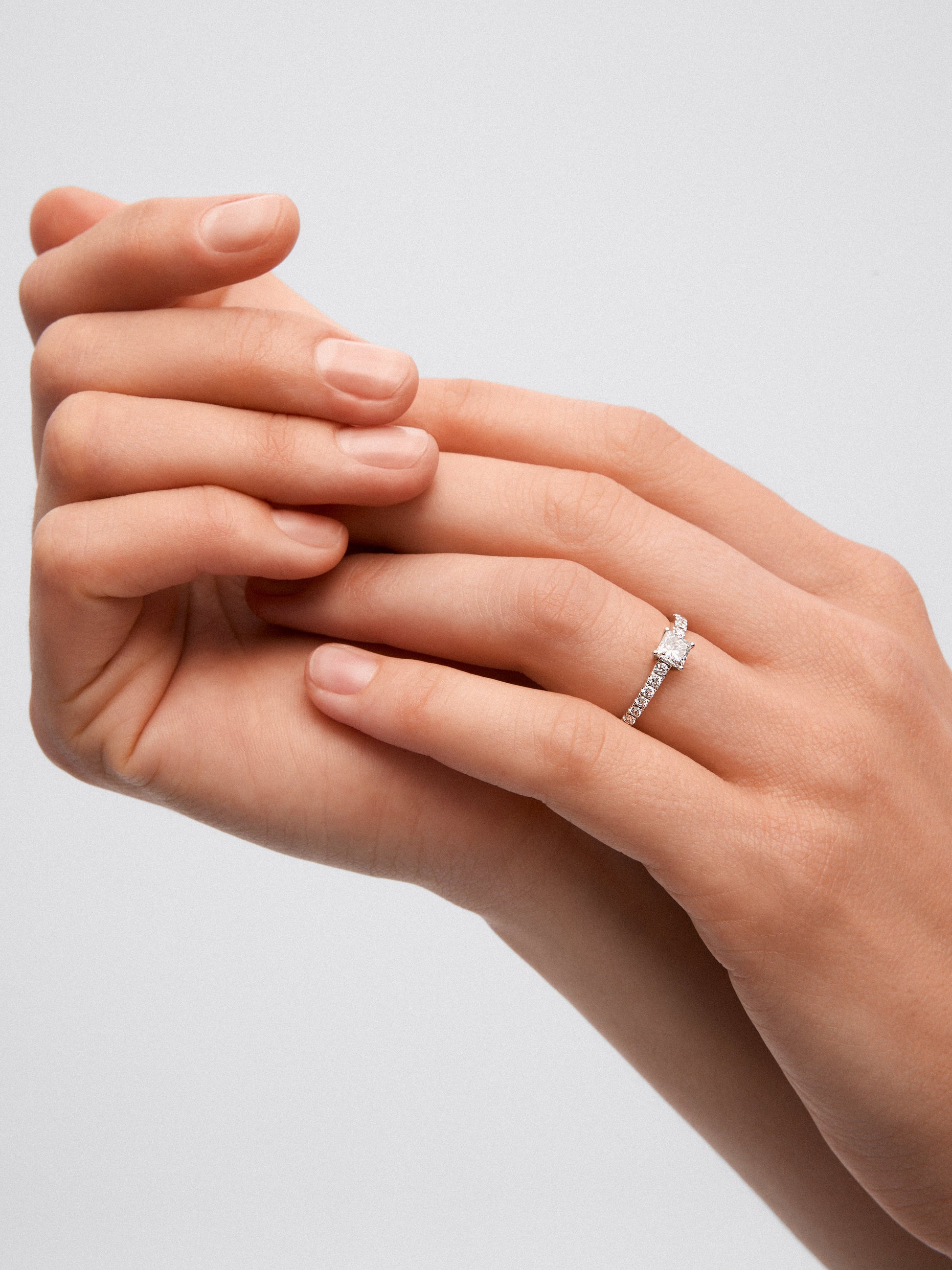 Anillo de oro blanco de 18K con diamante central en talla princesa de 0,5 cts y 14 diamantes con un total de 0,25 cts