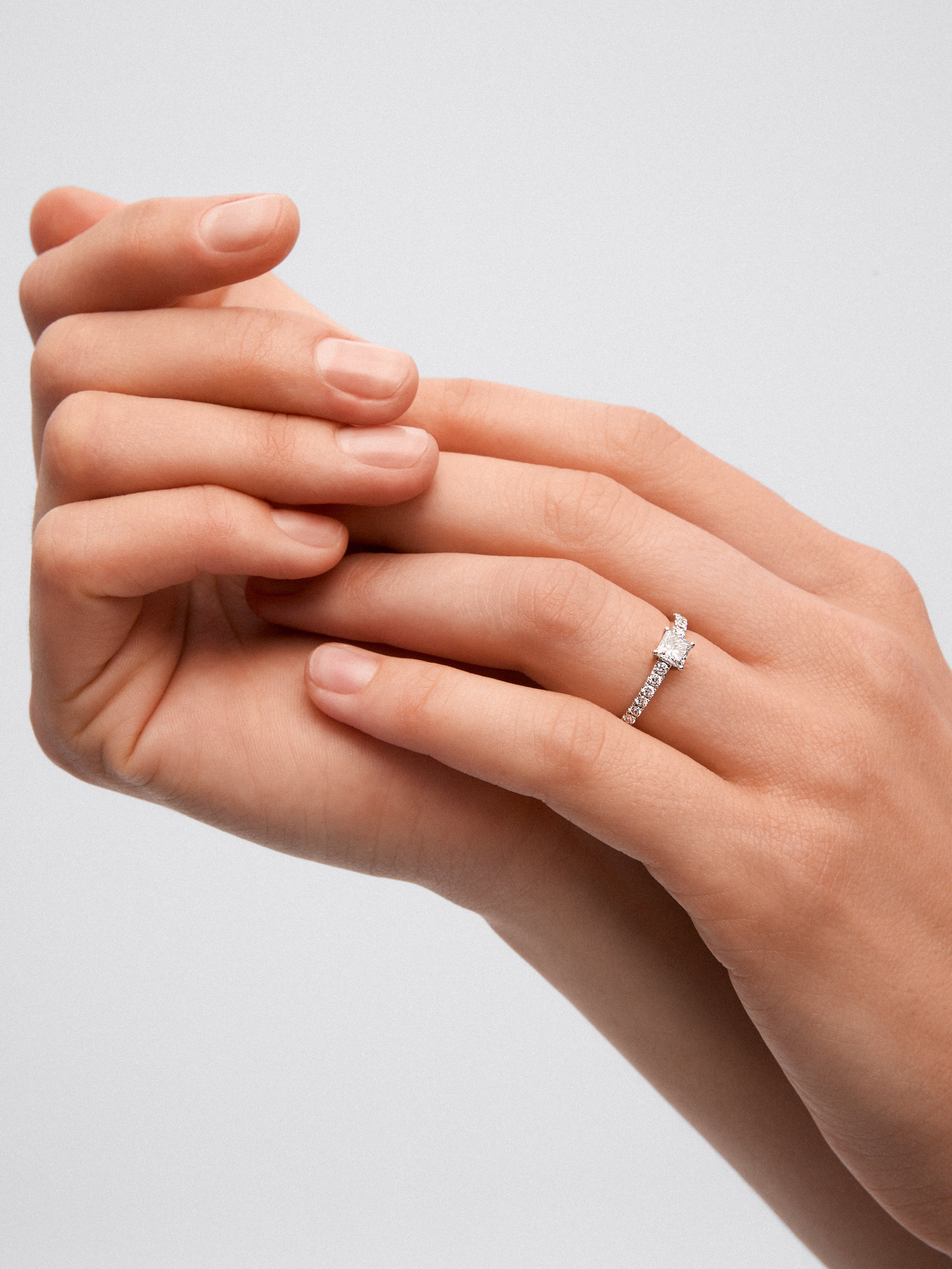 Anillo de oro blanco de 18K con diamante central en talla princesa de 0,5 cts y 14 diamantes con un total de 0,25 cts