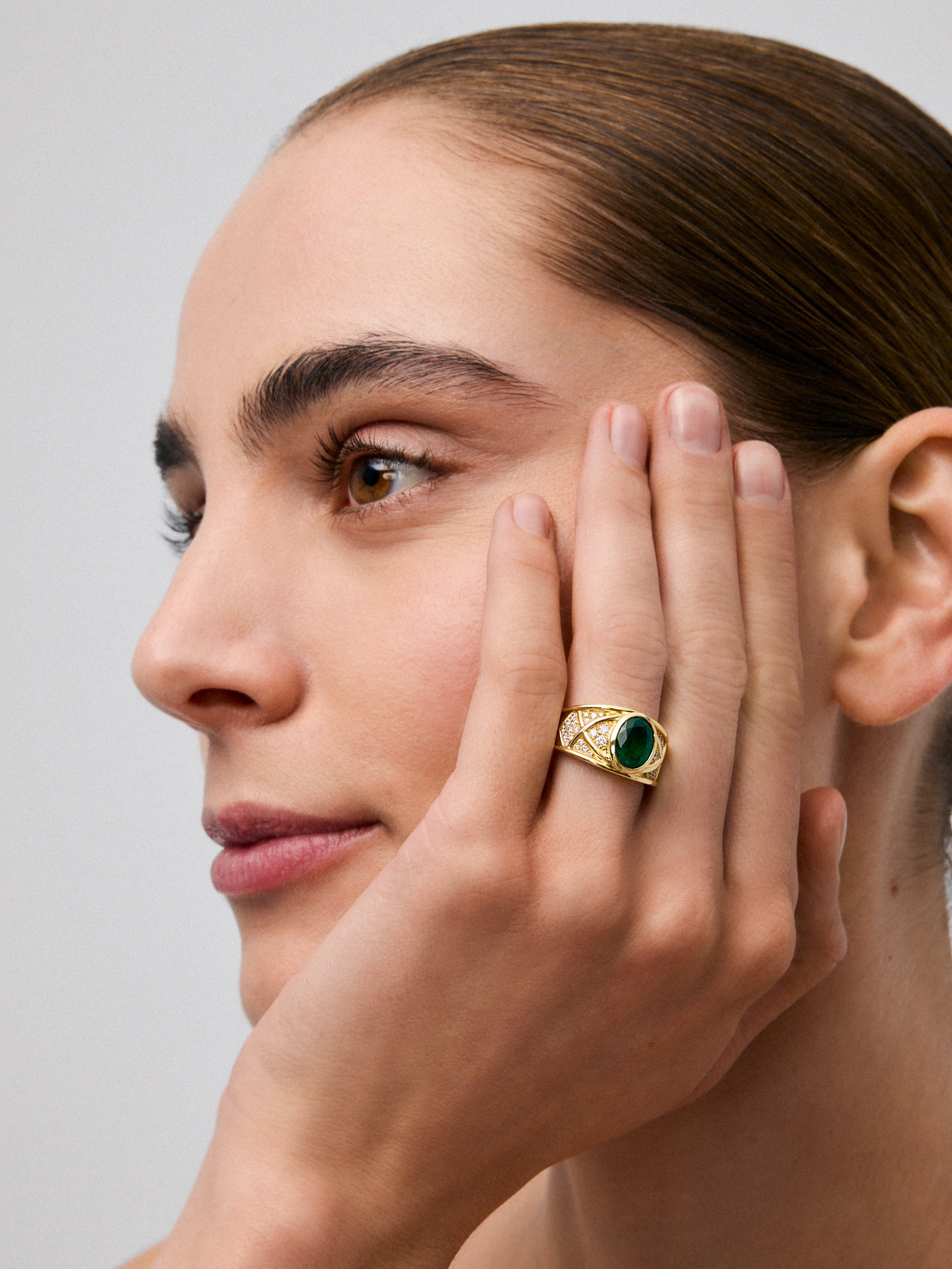 Anillo de oro amarillo de 18K con esmeralda en talla oval de 1,3 cts y 22 diamantes en talla brillante con un total de 0,3 cts