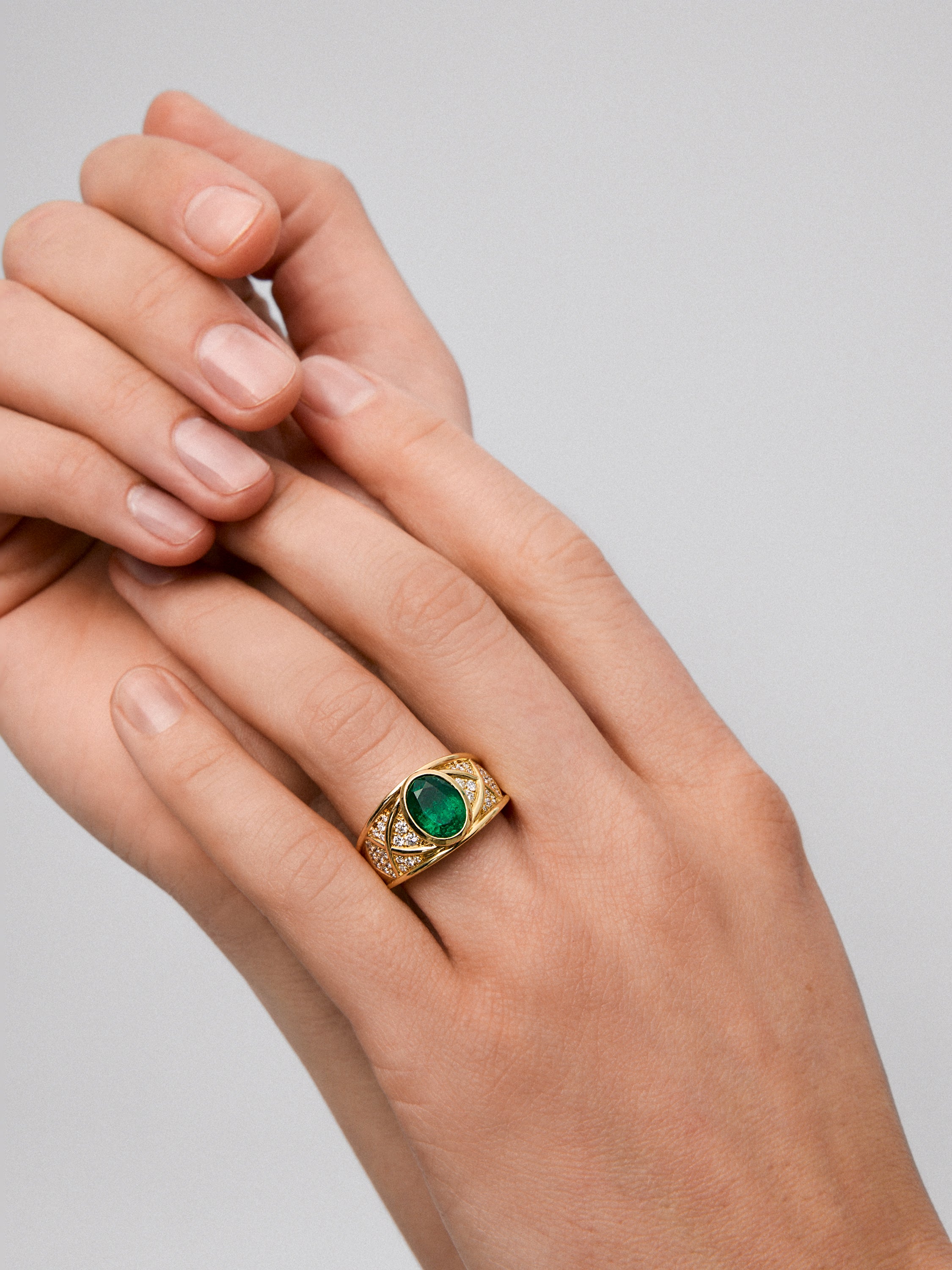 Anillo de oro amarillo de 18K con esmeralda en talla oval de 1,3 cts y 22 diamantes en talla brillante con un total de 0,3 cts
