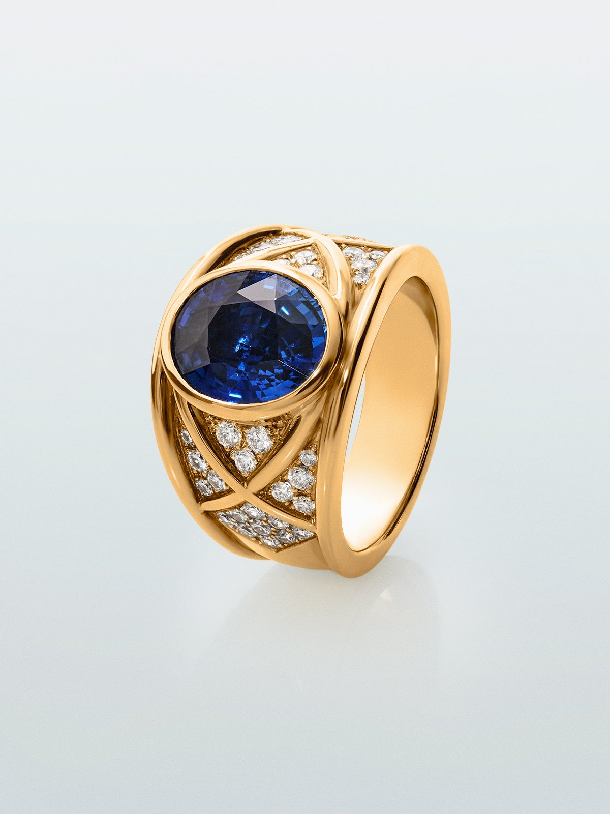 Anillo de oro amarillo de 18K con zafiro azul vivid en talla oval de 4,6 cts y 40 diamantes en talla brillante con un total de 0,5 cts