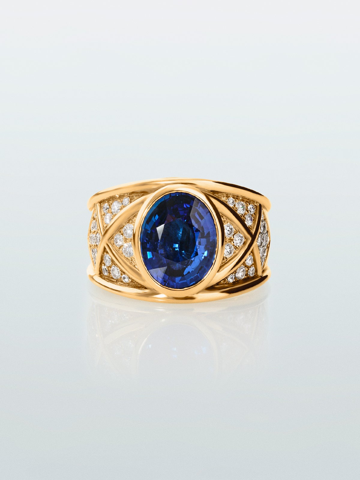 Anillo de oro amarillo de 18K con zafiro azul vivid en talla oval de 4,6 cts y 40 diamantes en talla brillante con un total de 0,5 cts