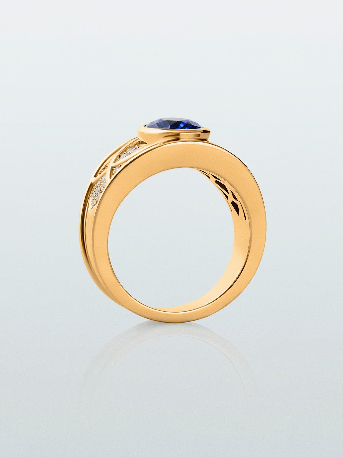 Anillo de oro amarillo de 18K con zafiro azul royal en talla oval de 2 cts y 42 diamantes en talla brillante con un total de 0,3 cts