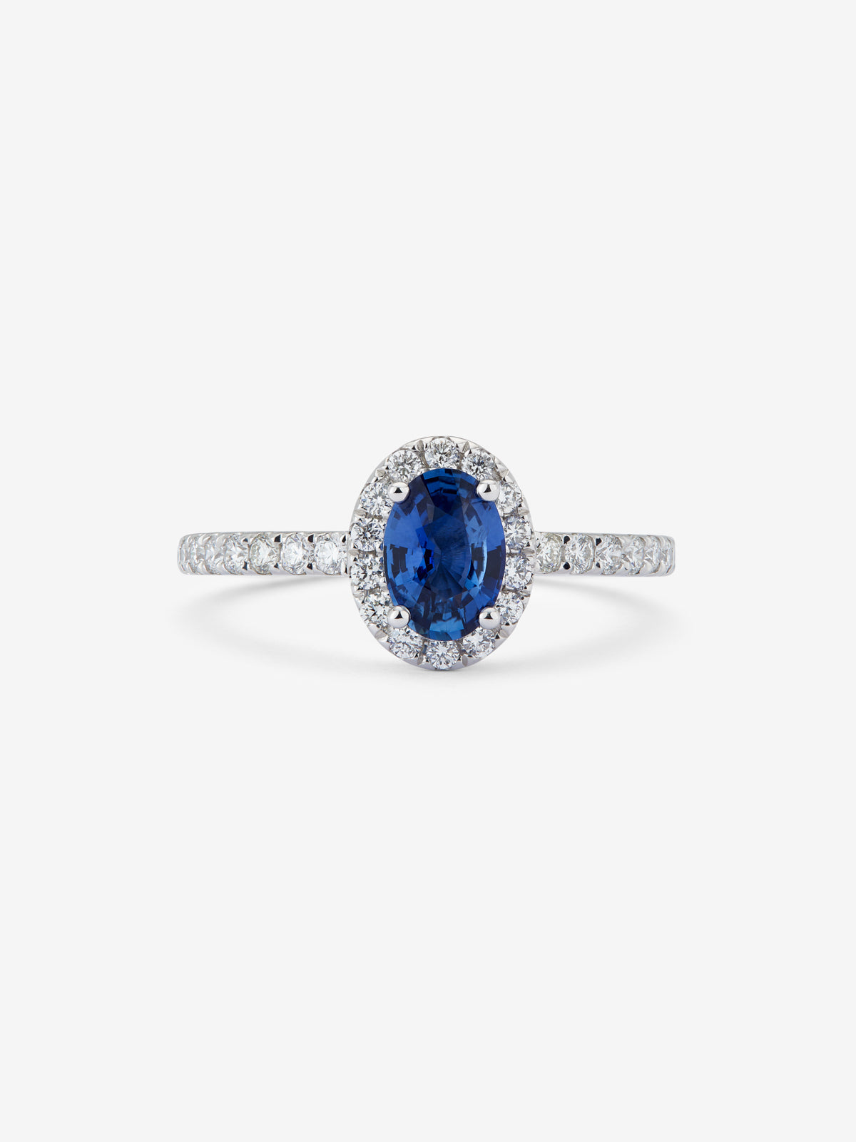 Anillo de oro blanco de 18K con zafiro azul en talla oval de 0,89 cts y orla de diamantes en talla brillante con un total de 0,34 cts