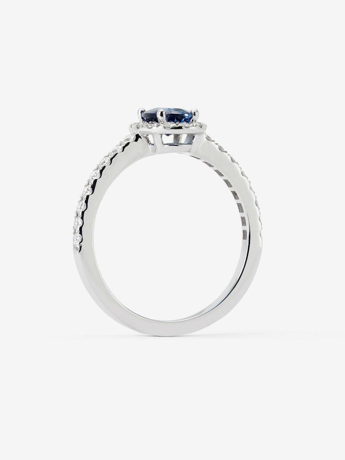 Anillo de oro blanco de 18K con zafiro azul en talla oval de 0,89 cts y orla de diamantes en talla brillante con un total de 0,34 cts