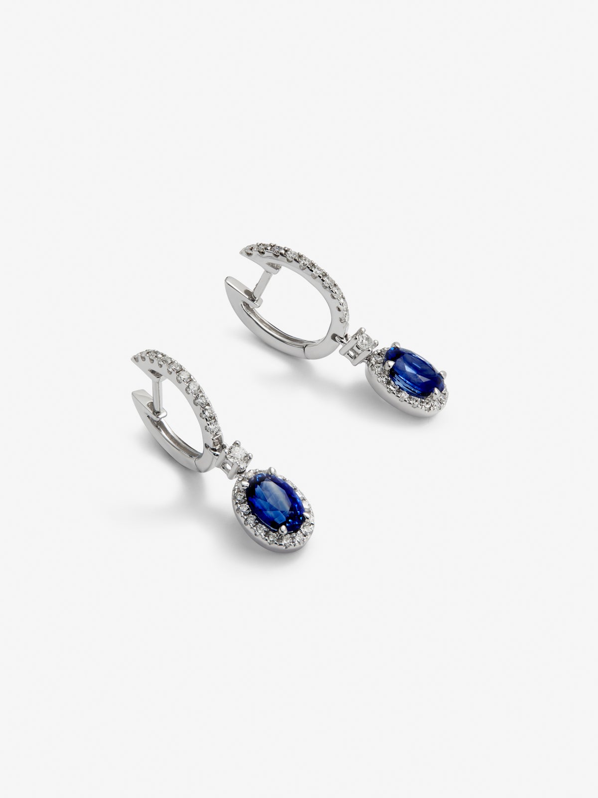 18K white gold earrings with 2 oval-cut blue sapphires with a total of 0.69 cts and 36 brilliant-cut diamonds with a total of 0.13 cts